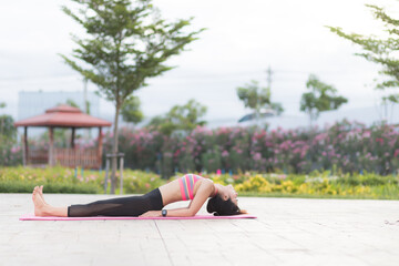 Young women do yoga outdoors on stone. women exercising yoga in the park. Young girl meditating in...