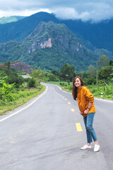 Naklejka premium Portrait image of a female traveler on a mountain road