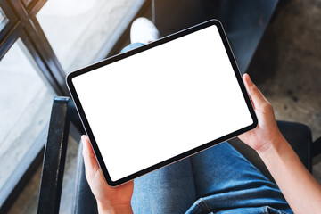 Top view mockup image of a woman holding black tablet pc with blank white desktop screen
