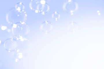 Beautiful clear soap bubbles float on blue background.