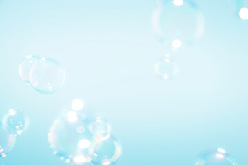 Beautiful clear soap bubbles float on blue background.