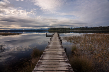 Fototapeta na wymiar The Jetty at Lake Mahinapua in the South Island of New Zealand on a still day with the clouds and mountains reflecting
