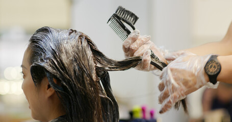 Woman dye her hair at beauty salon