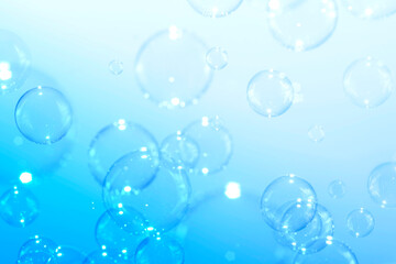 Clear soap bubbles float on a blue background. Bubbles abstract background