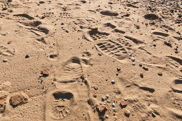 Fusspuren im Sand und Schuhabdrücke