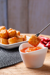.Squares of tapioca and cheese served with pepper jelly. Wooden table. Space for text - Dice of tapioca. Copy space