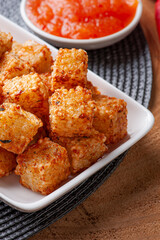 .Squares of tapioca and cheese served with pepper jelly. Wooden table. Space for text - Dice of tapioca