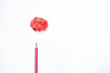 Red paper ball with a red pencil on a white background.
