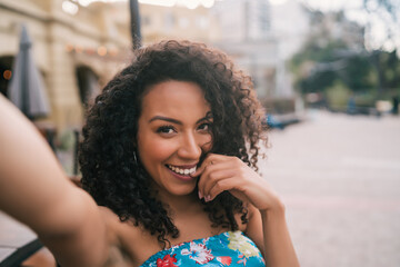 Afro american woman taking a selfie in the city.