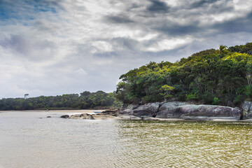 Imagem  do rio Itaguar&eacute;, itoral de S&atilde;o Paulo.  Nuvens dram&aacute;ticas, rio,  rochas e mata Atlantica.