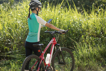 Fototapeta na wymiar Cyclist use smartphone for navigation when riding mountain bike on forest trail