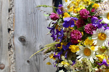 Bouquet of wild flowers on an old wooden background