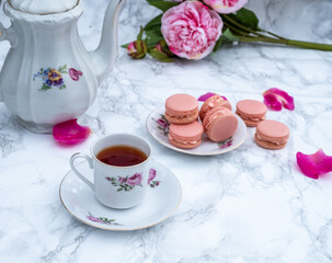 Cup of tea with macaroons on table.