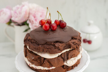 Obraz na płótnie Canvas chocolate cherry sponge cake with chocolate frosting