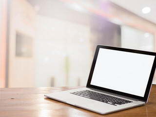 Fototapeta premium laptop with blank screen on table in the mall background.