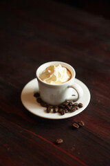 Coffee cup and coffee beans on wooden table.