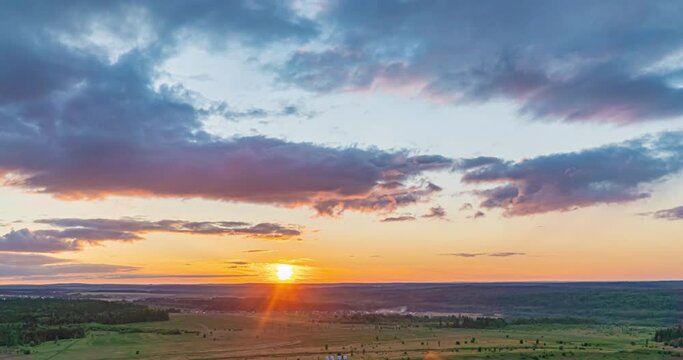 Beautiful evening sunset, time lapse, movement of clouds of a different level against the setting sun. Sun rays shine through the clouds, time lapse 4k.