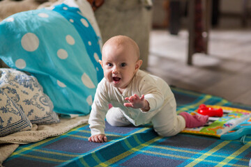 .7 month old baby girl on the bed looking at the camera