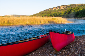 Red Canoes Beside The Brazos River at Sunrise Near Palo Pinto, Texas,USA