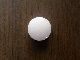 Small white color Naphthalene mothball on wood background