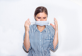 young woman in a blue striped shirt in a medical mask. remedy for coronavirus, pandemic, covid 19, pneumonia. 