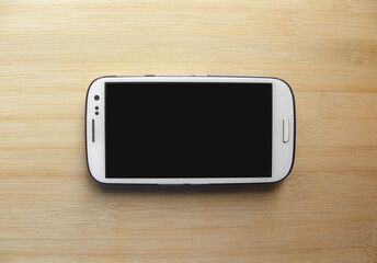White color smartphone on wood background