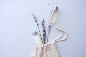Composition with lavender and organic cosmetics In eco bag on blue background. Organic SPA beauty products for hair and body care. Flat lay, top view. SPA branding mockups.