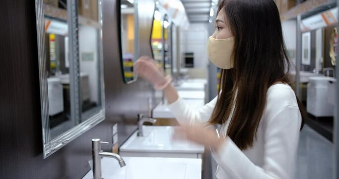 Young asian woman try washing hands at bathroom reopening store.