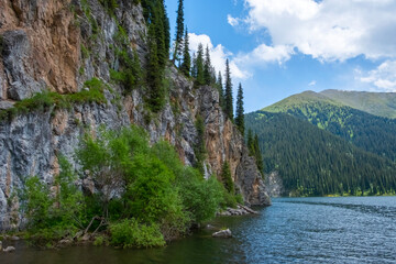 Fototapeta na wymiar Beautiful view to Middle Kolsai or Mynzhylky lake with mountains background. Summer vacation concept. Scenic travel background. Travel in Kazakhstan concept.
