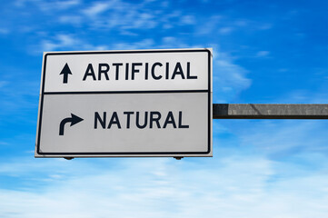 Artificial versus natural. White two street signs with arrow on metal pole. Directional road,...