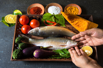 Cooking preparation of fish and vegetables Indian style with use of selective focus.