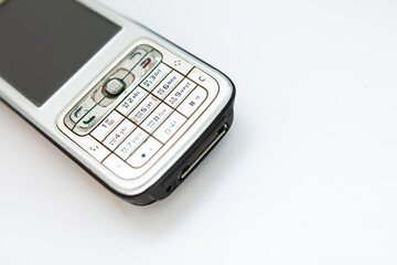 old push-button smartphone on a white background