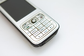old push-button smartphone on a white background