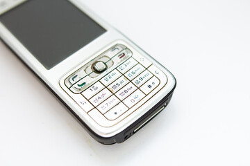 old push-button smartphone on a white background