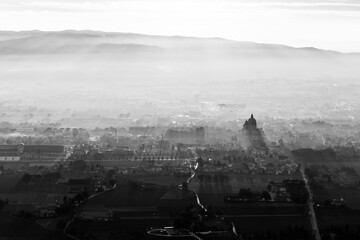 Sunset above S.Maria degli Angeli town (Assisi, Umbria, Italy) with mist and shadows