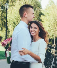 Foto auf Leinwand  Girl with a bouquet of kaal hugs a guy and looks into the frame, girl hugs a guy and smiles © Катя Данилюк