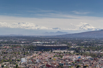 aerial view of Azteca soccer stadium and iconic snowed volcanoes in the back