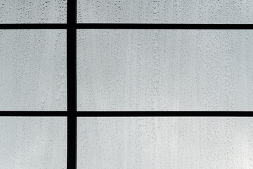 small water drop on glass window black metal frame rainy season background