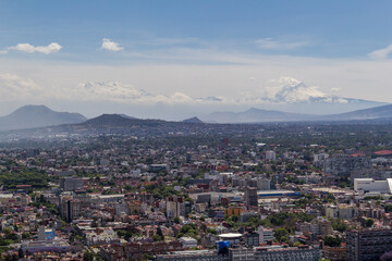Fototapeta na wymiar aerial view of typical Mexican living and working area in the southern part of town, with volcanoes in the back