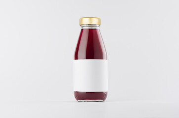 Violet berries juice in glass bottle with gold cap and white blank label mock up on white...