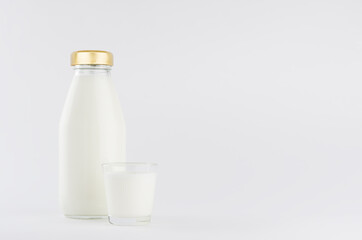 Milk, white dairy product in glass bottle  mock up with glass on soft light white background, copy space.