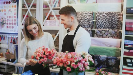 Young couple work at flower shop.