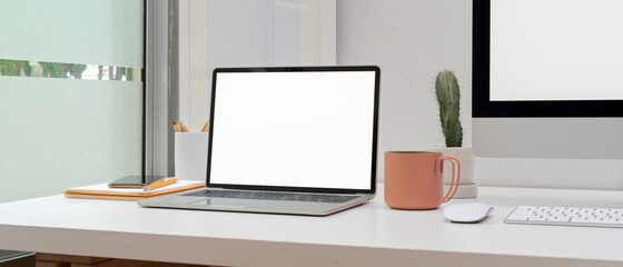 Home office with mock up computer, laptop, supplies and decoration on white table