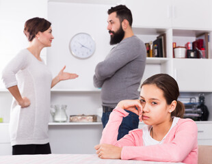 Young parents arguing with each other while their daughter at home