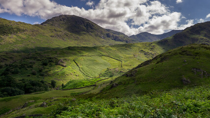 A view of a circular farm wall is light by summers sunshine in th Langdales, The English Lake District UK