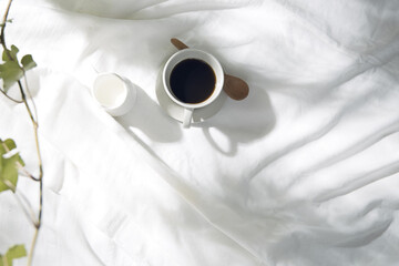 白い布とコーヒーカップのある窓辺