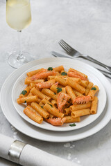 Penne pasta or Italian rigatoni with langoustines and  tomato sauce in white plate top view. seafood pasta recipe