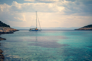 Fototapeta na wymiar Sailing boat at distant remote island paradise with exotical vivid colors.