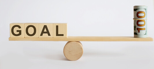 Seesaw Showing Balance Between money And word GOAL