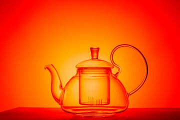glass teapot on an orange background.